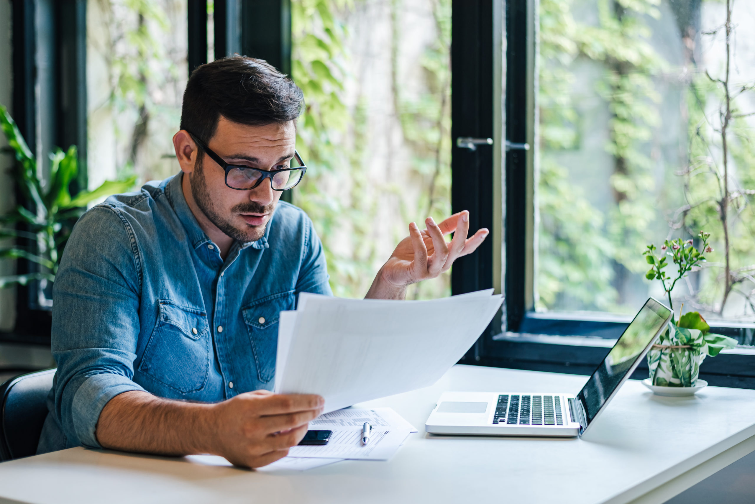 Hardworking business accountant, checking the company budget for the year in his office.